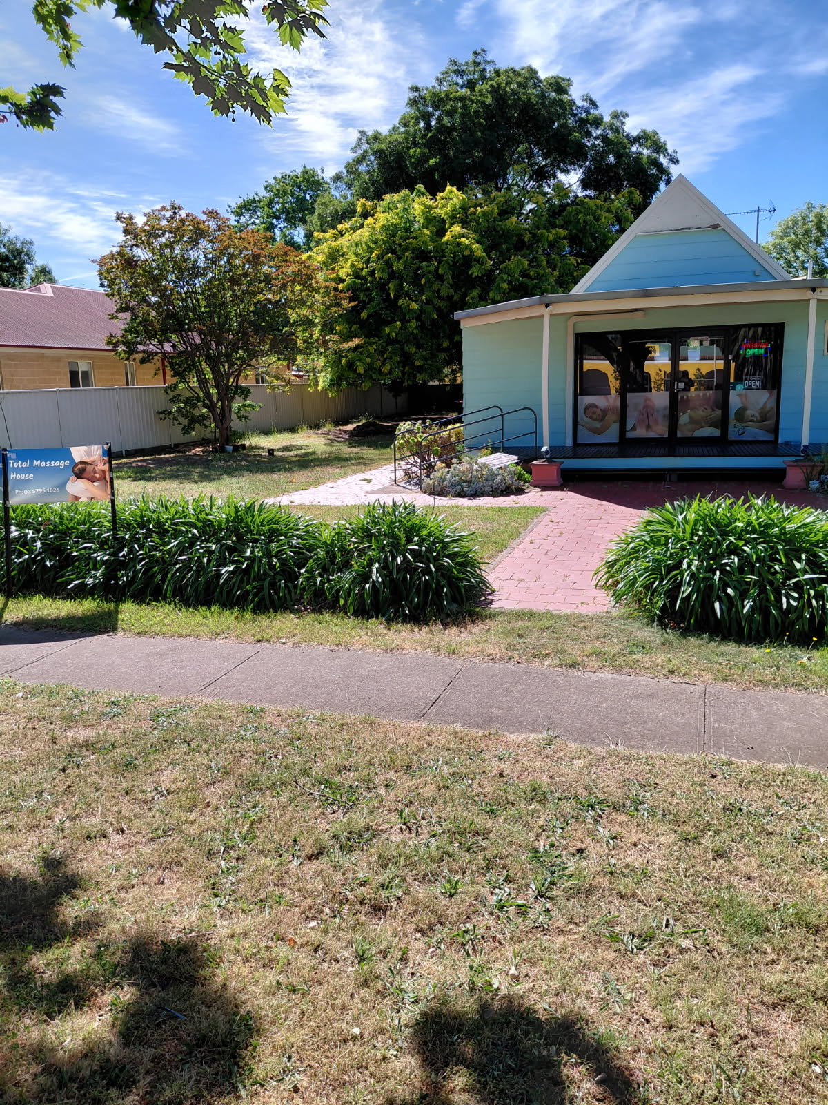 Owner Amy standing in the main entrance doorway of the massage shop
