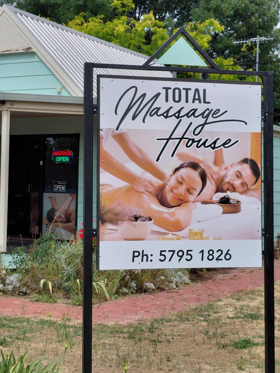 Close-up of Total Massage House sign visible from the street